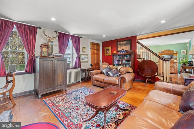 living room with radiator, a wealth of natural light, and light hardwood / wood-style flooring