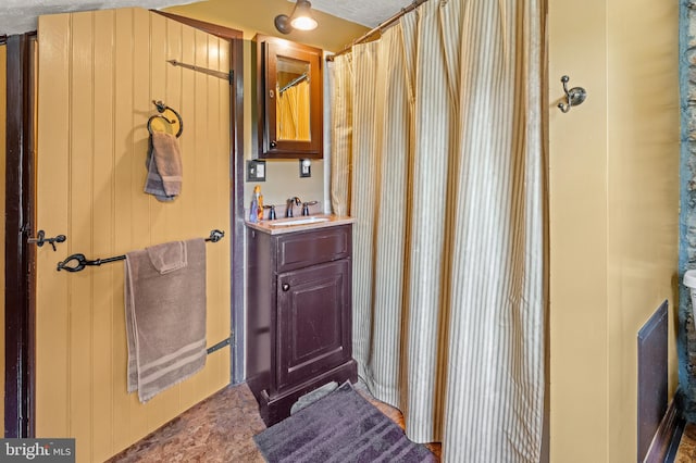 bathroom with a shower with curtain, vanity, and a textured ceiling