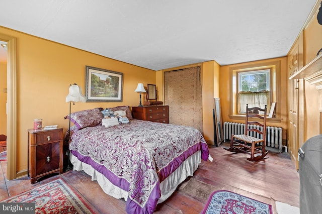 bedroom featuring hardwood / wood-style flooring and radiator