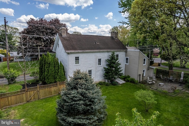 rear view of house featuring a patio and a lawn