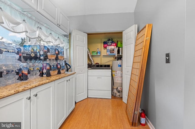 washroom with washer / dryer, light hardwood / wood-style flooring, and water heater