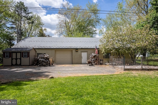 view of front facade with a shed, a front lawn, and a garage