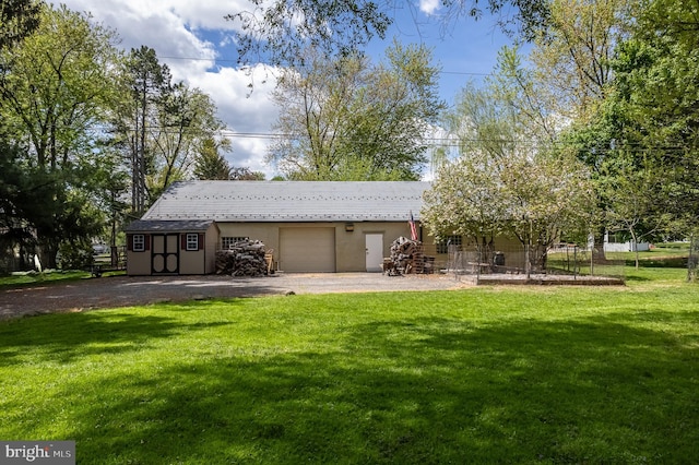 view of front facade with a front yard, a shed, and a garage