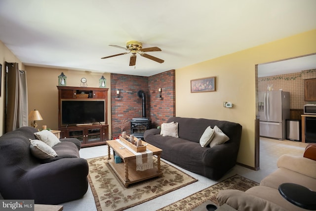 living room featuring a wood stove, ceiling fan, and light carpet