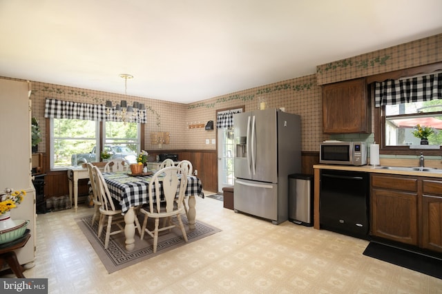 dining area with a chandelier, sink, and light tile flooring