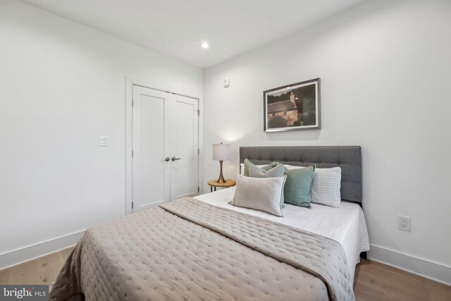 bedroom with wood-type flooring and a closet