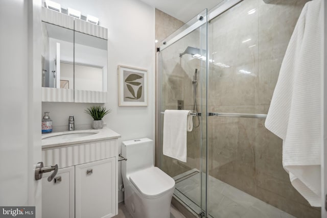 bathroom with vanity, toilet, and a shower with shower door