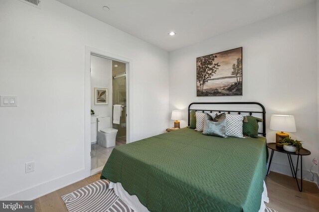 bedroom with wood-type flooring and connected bathroom