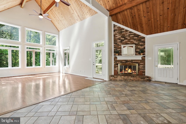 unfurnished living room featuring a healthy amount of sunlight, a fireplace, wooden ceiling, and beamed ceiling