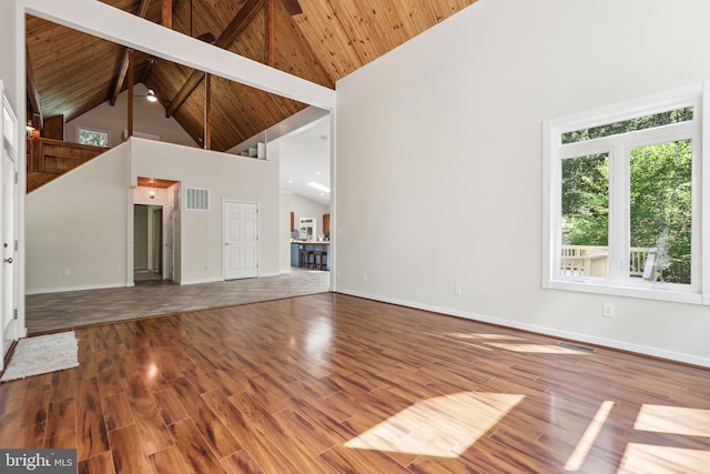 unfurnished living room featuring wood ceiling, wood-type flooring, high vaulted ceiling, and beamed ceiling