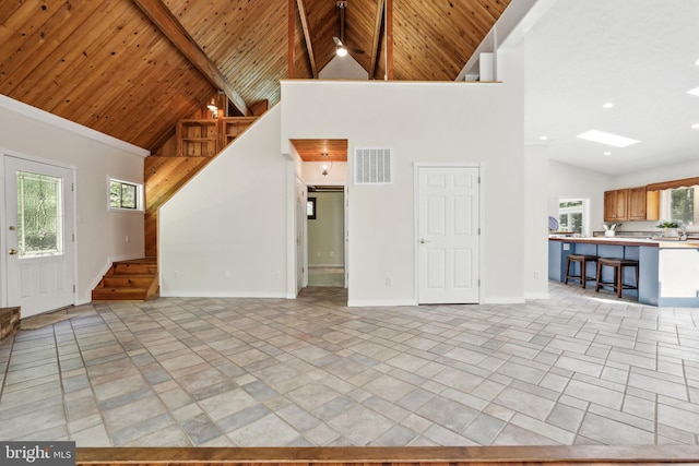 unfurnished living room featuring wood ceiling and high vaulted ceiling