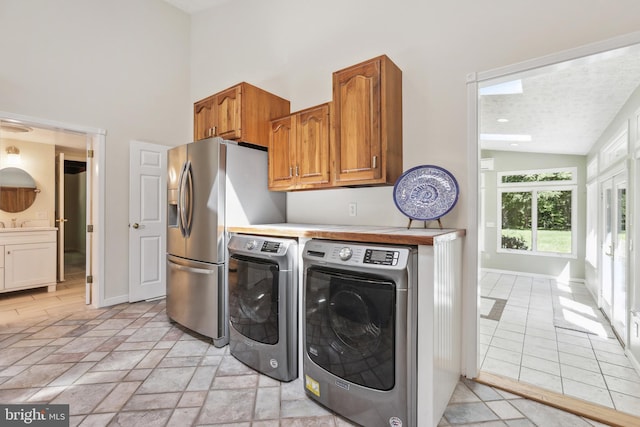 clothes washing area featuring a high ceiling, washer and dryer, and a textured ceiling