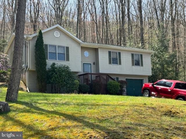 split foyer home featuring a garage and a front yard