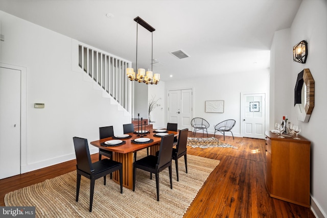 dining room with hardwood / wood-style flooring and a chandelier