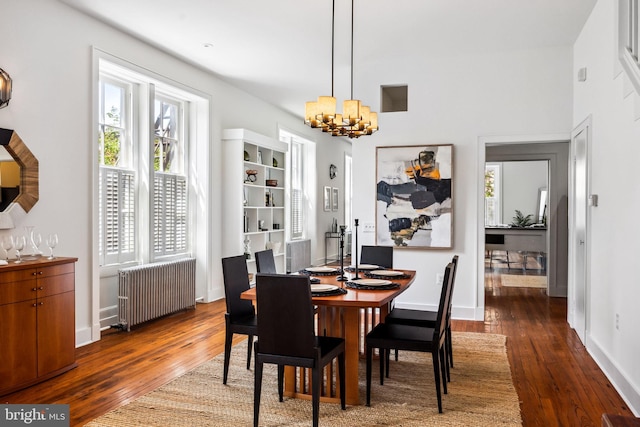 dining space with an inviting chandelier, radiator heating unit, and dark hardwood / wood-style floors