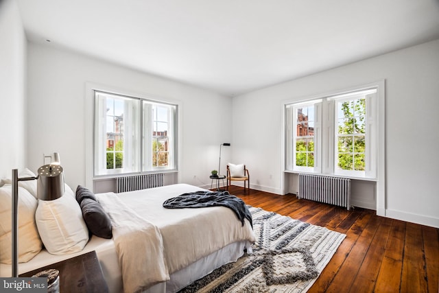 bedroom with multiple windows, radiator heating unit, and dark hardwood / wood-style floors