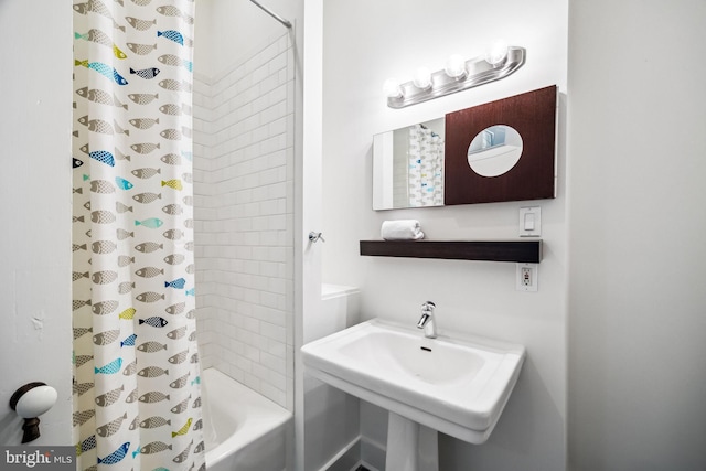 bathroom featuring shower / tub combo with curtain and sink