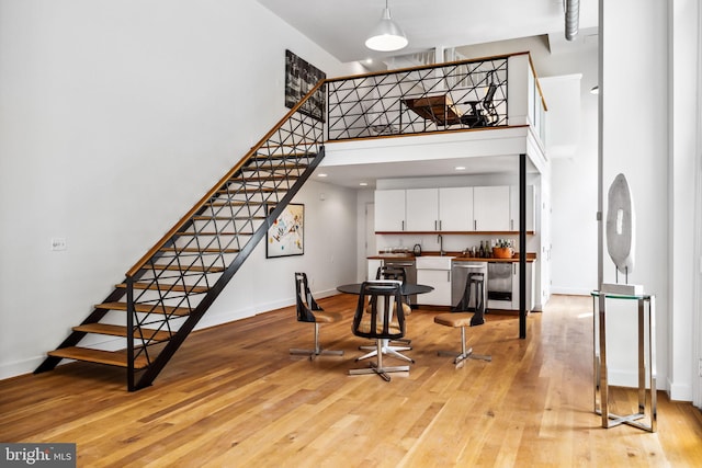 interior space with light wood-type flooring and a high ceiling