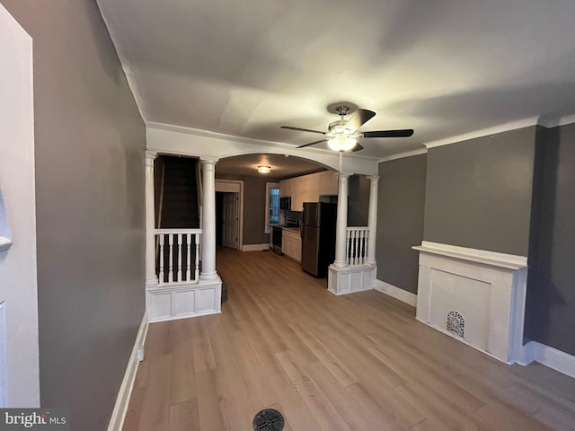 interior space featuring ceiling fan, crown molding, light wood-type flooring, and decorative columns