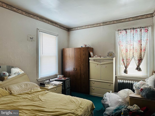 carpeted bedroom featuring multiple windows and radiator heating unit