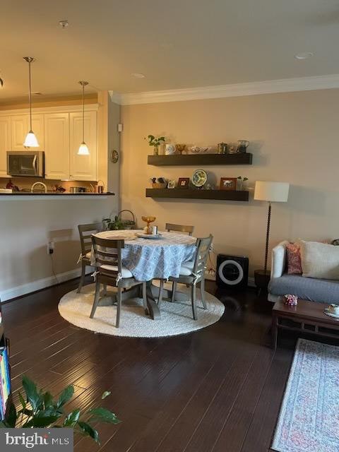 dining space featuring hardwood / wood-style floors and ornamental molding