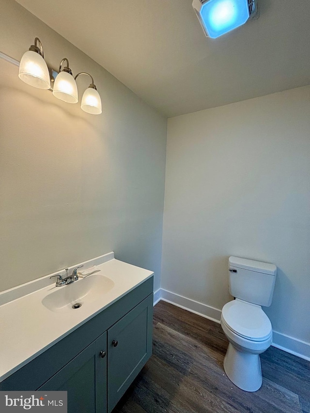 bathroom featuring vanity, wood-type flooring, and toilet