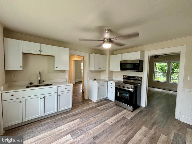 kitchen featuring appliances with stainless steel finishes, light hardwood / wood-style floors, white cabinetry, and sink