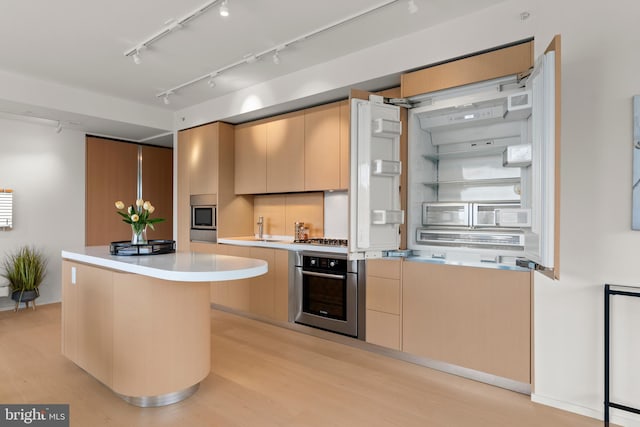 kitchen featuring light hardwood / wood-style floors, sink, stainless steel appliances, and a center island