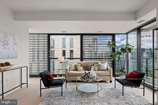 living room with light hardwood / wood-style flooring and a wall of windows