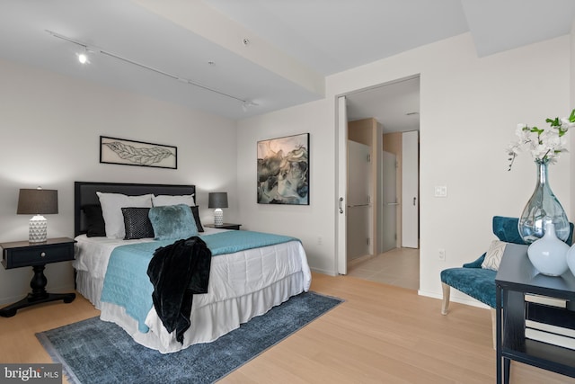 bedroom featuring track lighting and light hardwood / wood-style floors