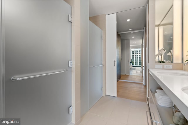 bathroom with tile patterned flooring, an enclosed shower, and vanity