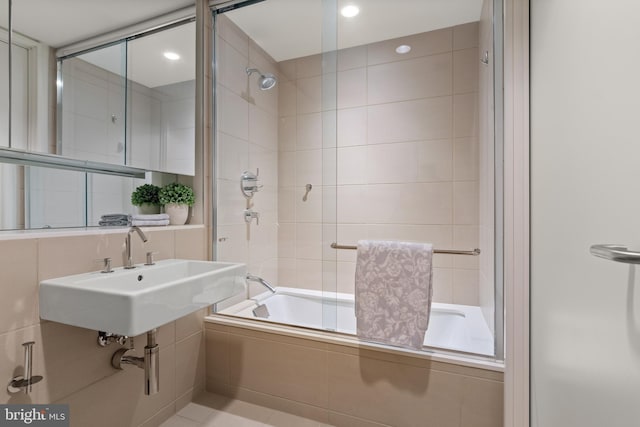 bathroom featuring shower / bath combination with glass door and sink