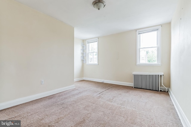 carpeted empty room with radiator heating unit