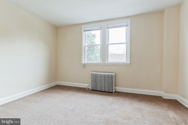 spare room with carpet flooring and radiator heating unit