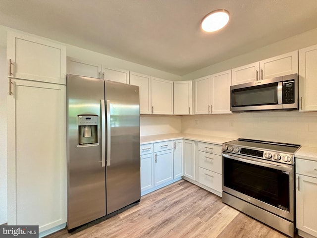 kitchen with white cabinets, light wood-type flooring, stainless steel appliances, and tasteful backsplash