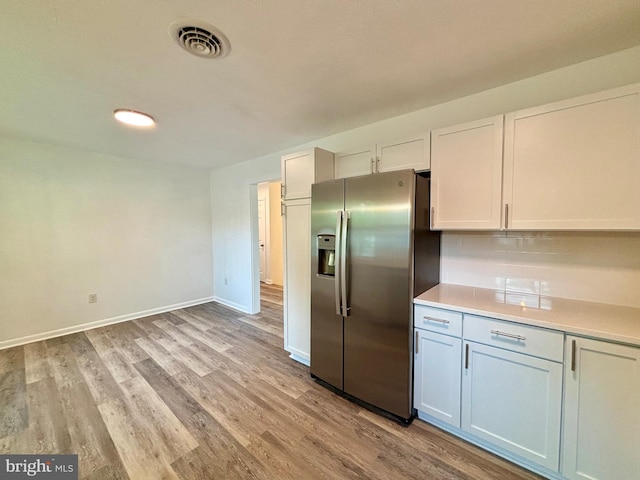 kitchen featuring white cabinetry, stainless steel refrigerator with ice dispenser, and light wood-type flooring