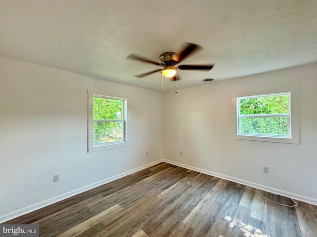 unfurnished room with a textured ceiling, dark hardwood / wood-style floors, and ceiling fan