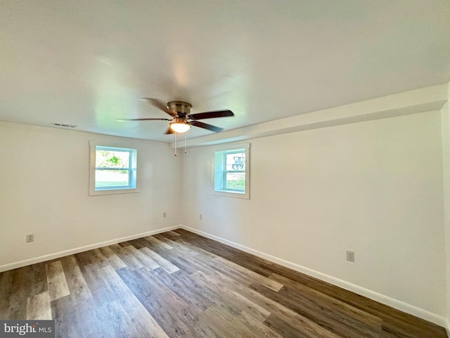 empty room with plenty of natural light, ceiling fan, and wood-type flooring