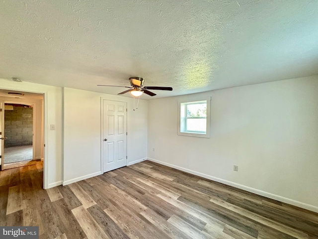 unfurnished bedroom featuring a textured ceiling, hardwood / wood-style flooring, and ceiling fan