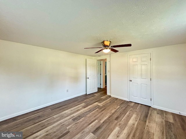 unfurnished bedroom featuring hardwood / wood-style flooring, ceiling fan, and a textured ceiling