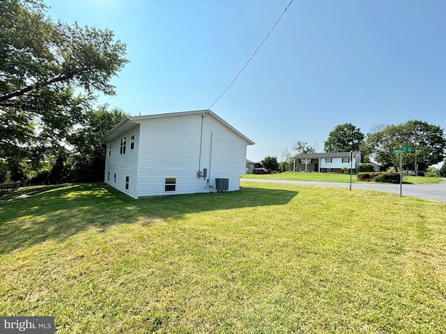 view of property exterior with cooling unit and a lawn