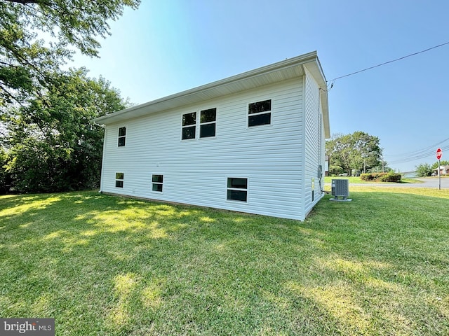 view of property exterior featuring cooling unit and a lawn