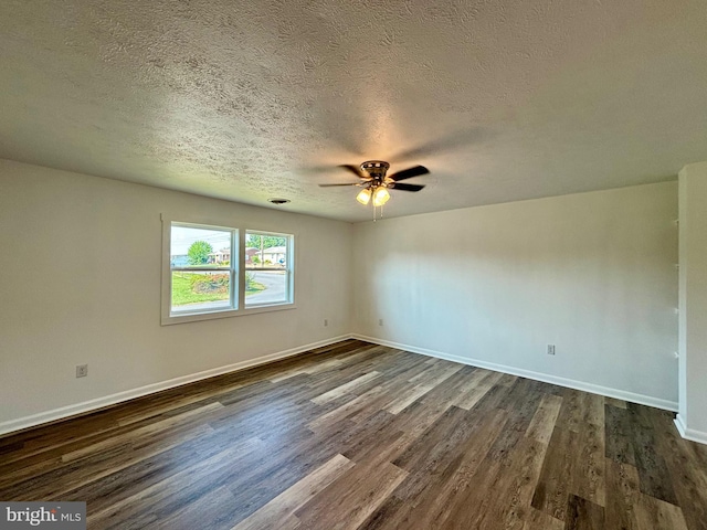 spare room with dark hardwood / wood-style floors, ceiling fan, and a textured ceiling