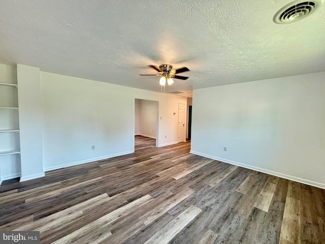 spare room with a textured ceiling and dark hardwood / wood-style floors