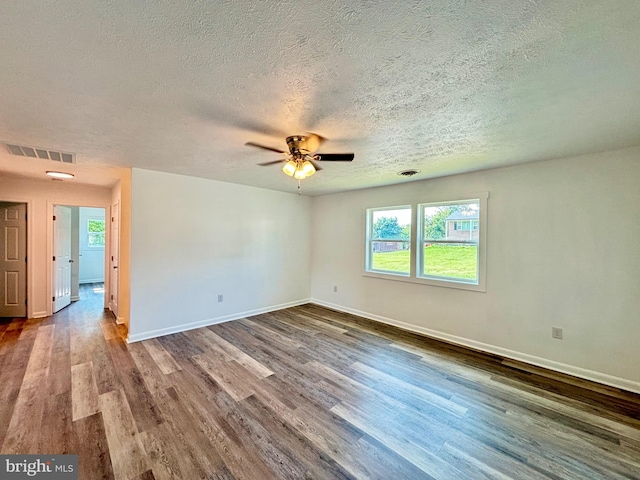 empty room featuring ceiling fan, wood-type flooring, and a textured ceiling