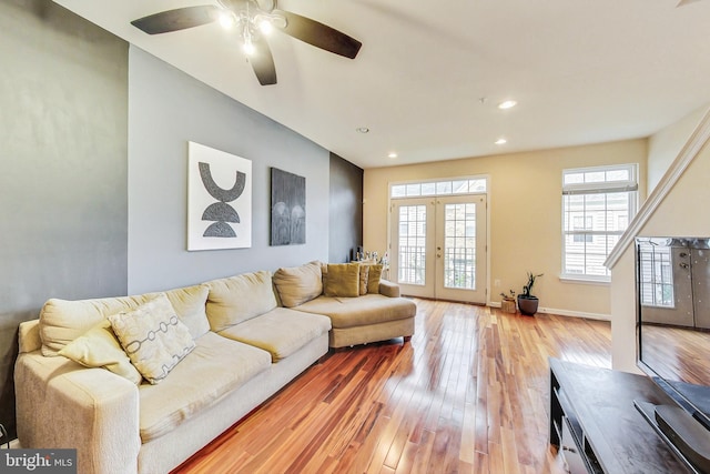 living room featuring ceiling fan, french doors, and light hardwood / wood-style floors