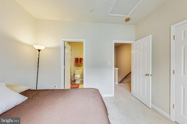 bedroom featuring ensuite bathroom and light carpet