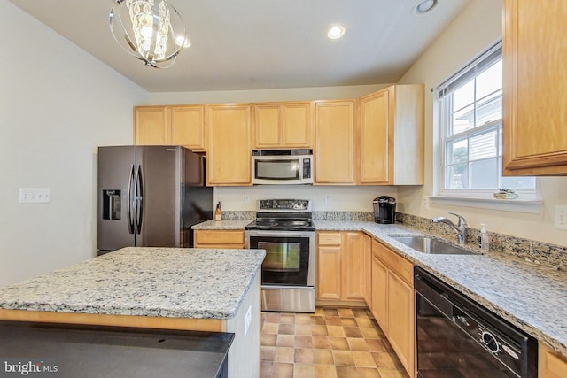 kitchen featuring appliances with stainless steel finishes, a chandelier, a kitchen island, and sink