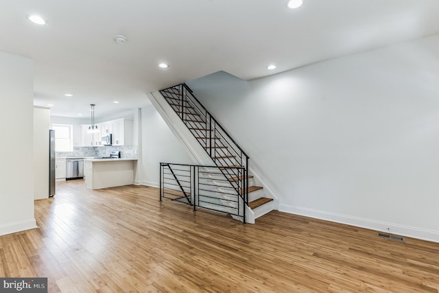 staircase featuring light hardwood / wood-style floors