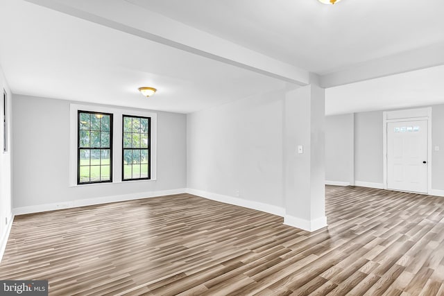 empty room with light wood-style flooring and baseboards